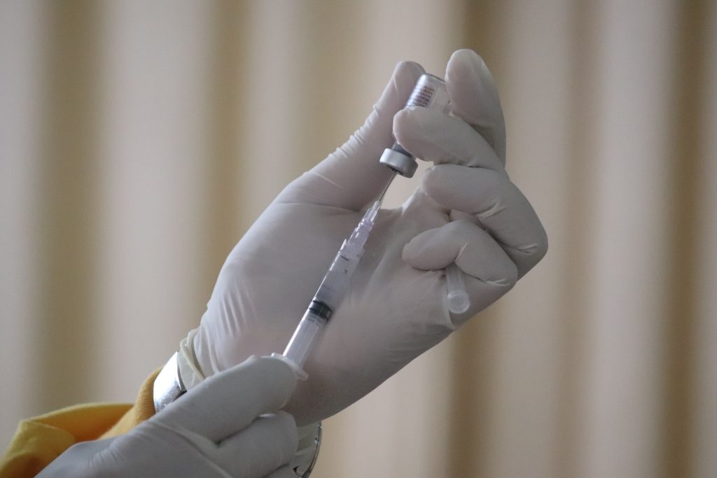 Syringe withdrawing from vaccine vial