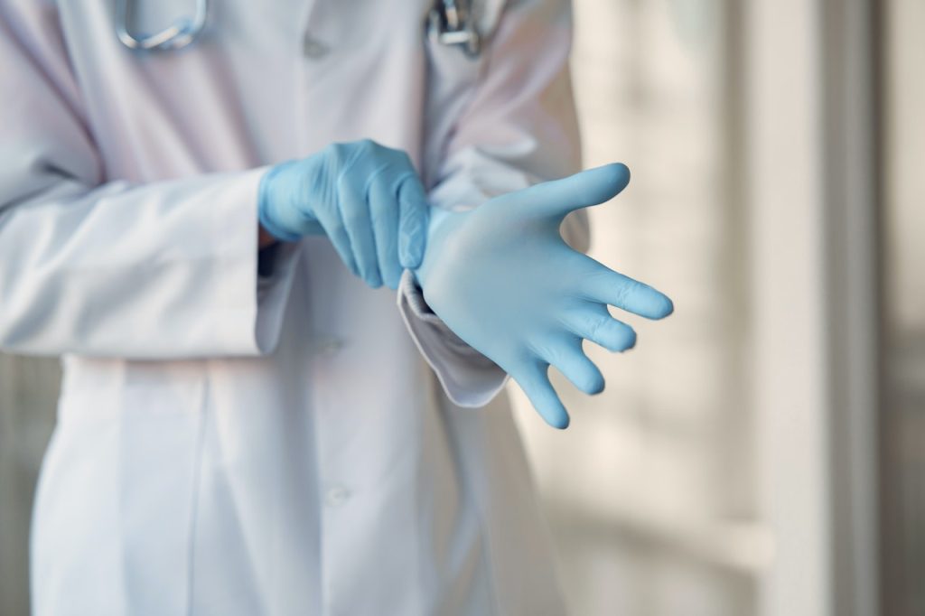 Healthcare worker pulling on gloves